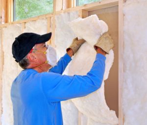 Technician installing insulation in a home