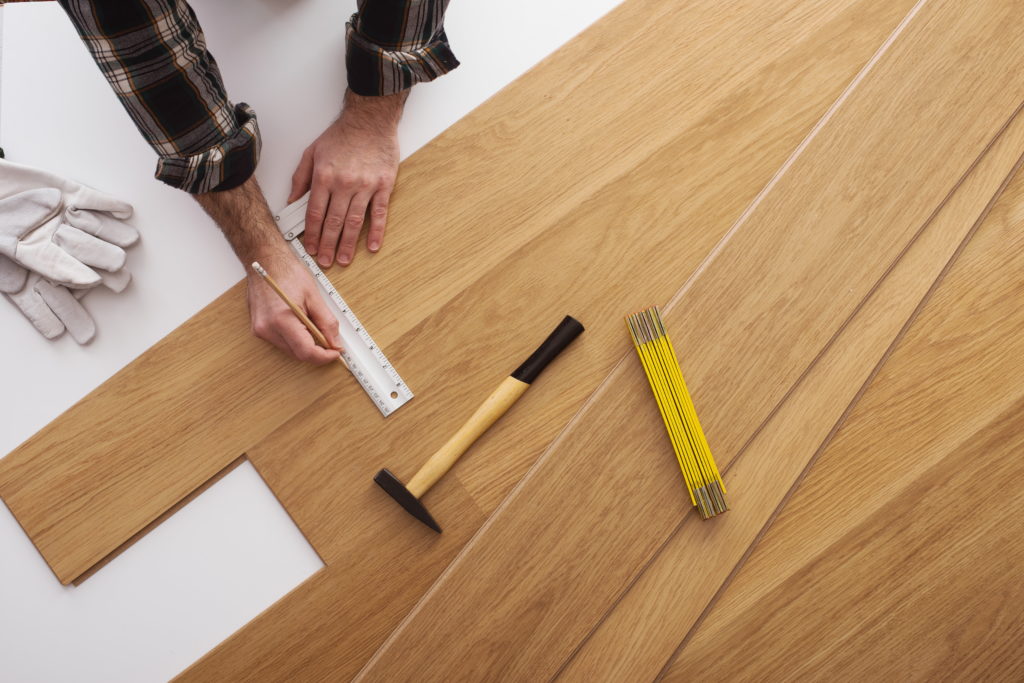 Contractor measuring flooring panels