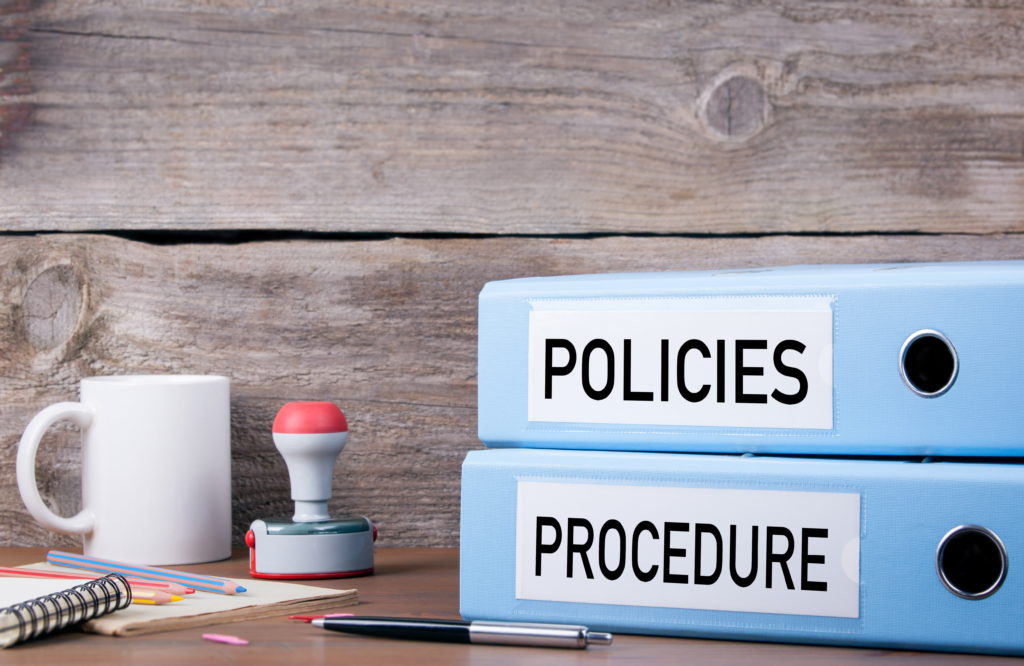 Policies and procedures binder on desk