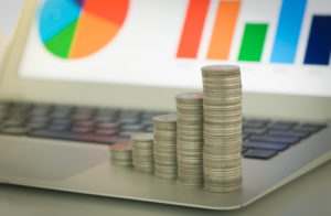 Coins stacked on laptop