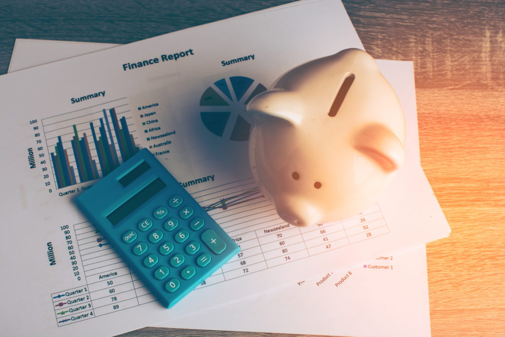 Piggy bank with calculator and finance report