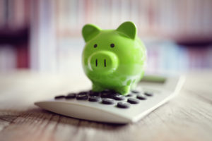 Green Piggy bank on a calculator