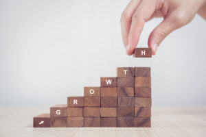 Stack of wooden blocks as step stair that reads "growth"
