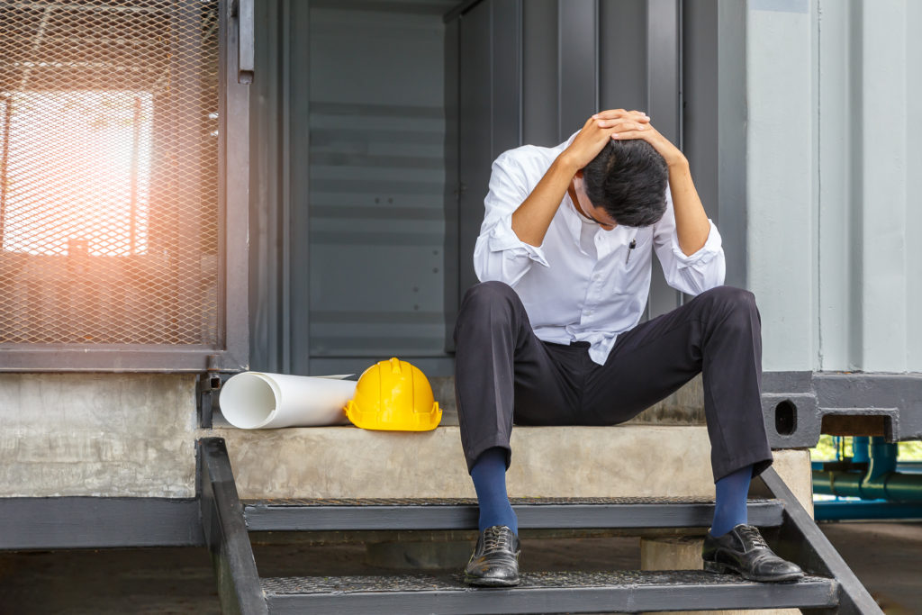 Young engineer suffering stress working at construction site