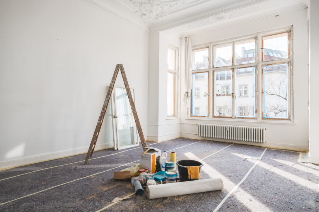 Large room with windows under construction with paint on the floor