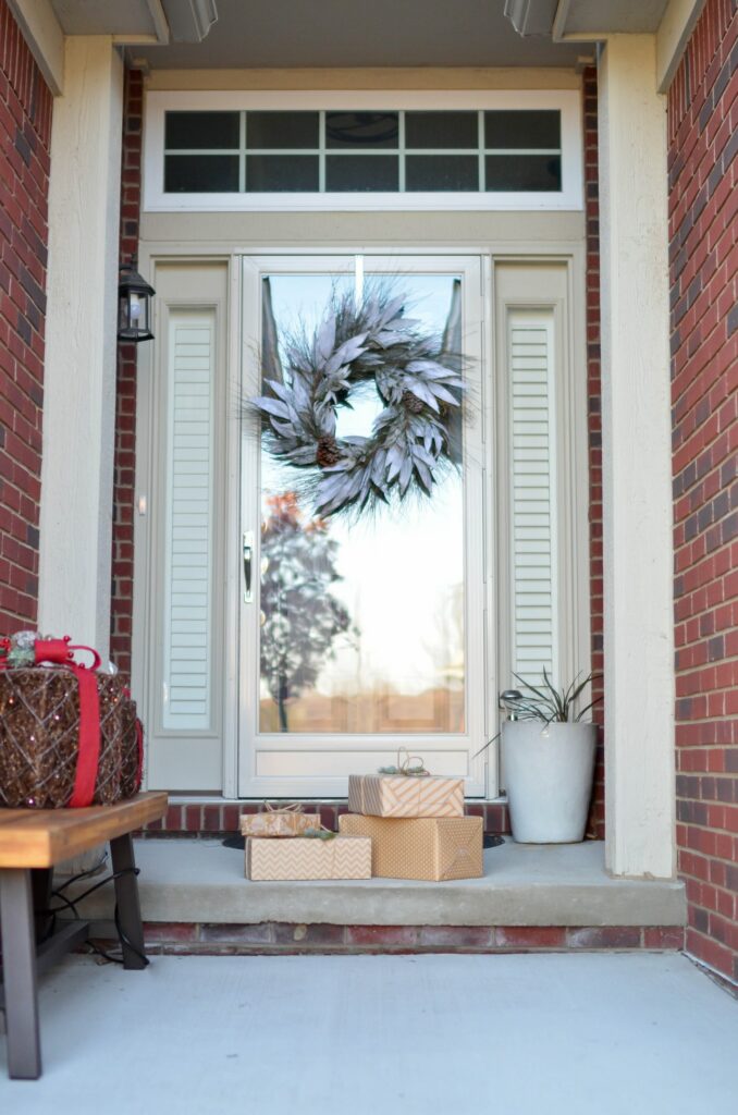 Presents on the doorstep of a home decorated for the holidays