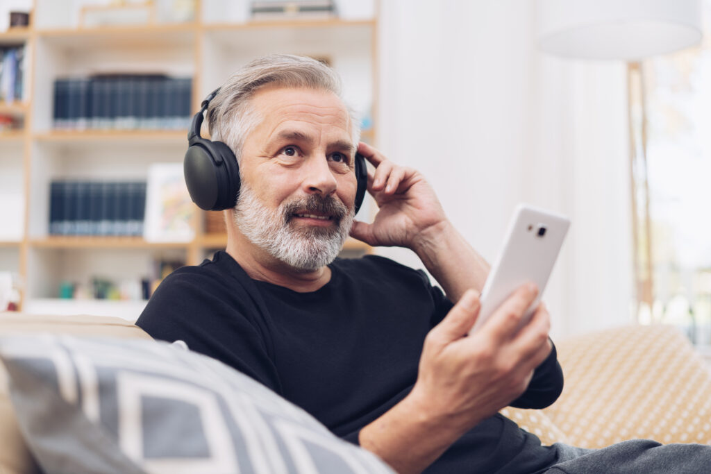 Man using his mobile phone for listening to music with headphones on