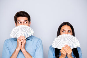 Photo of man and women with a fan of money in hands