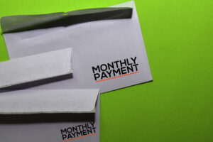 Monthly payment on post card on office desk