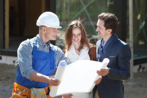 Dealer showing construction plan to a man and women