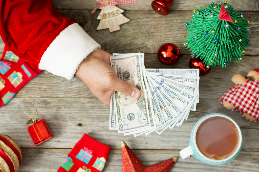 A hand holding cash money against Christmas background