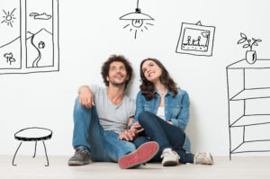 Man and women sitting while holding hands and envisioning their dream home