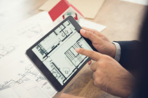 Architect presenting house floor plan to client on tablet computer