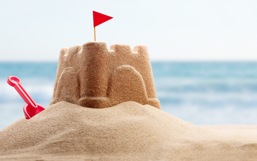 Sand castle with a shovel on the beach