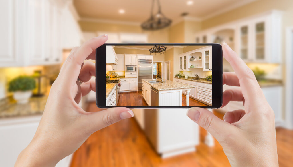Person taking a landscape picture of a completed kitchen remodel