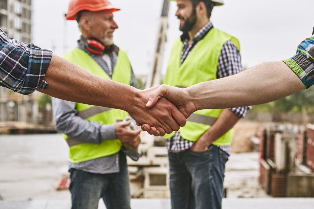 New home improvement business with contractors shaking hands on jobsite
