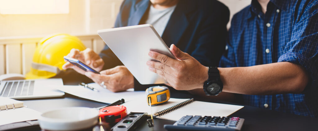 home improvement contractors discuss with colleagues financing options using tablets.