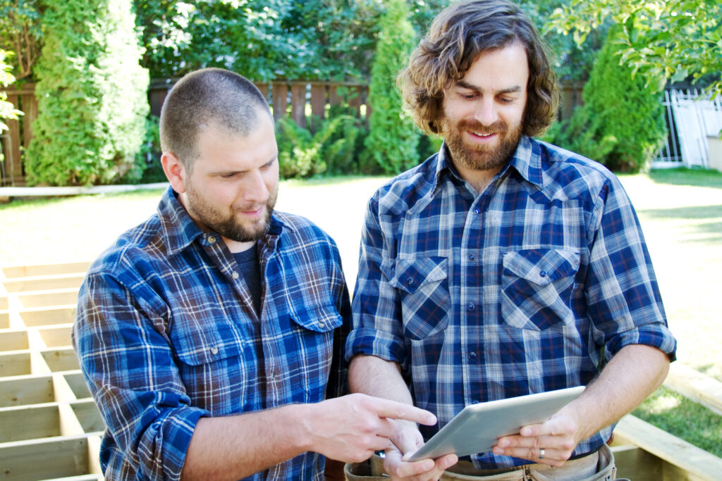 two carpenters planning on tablet