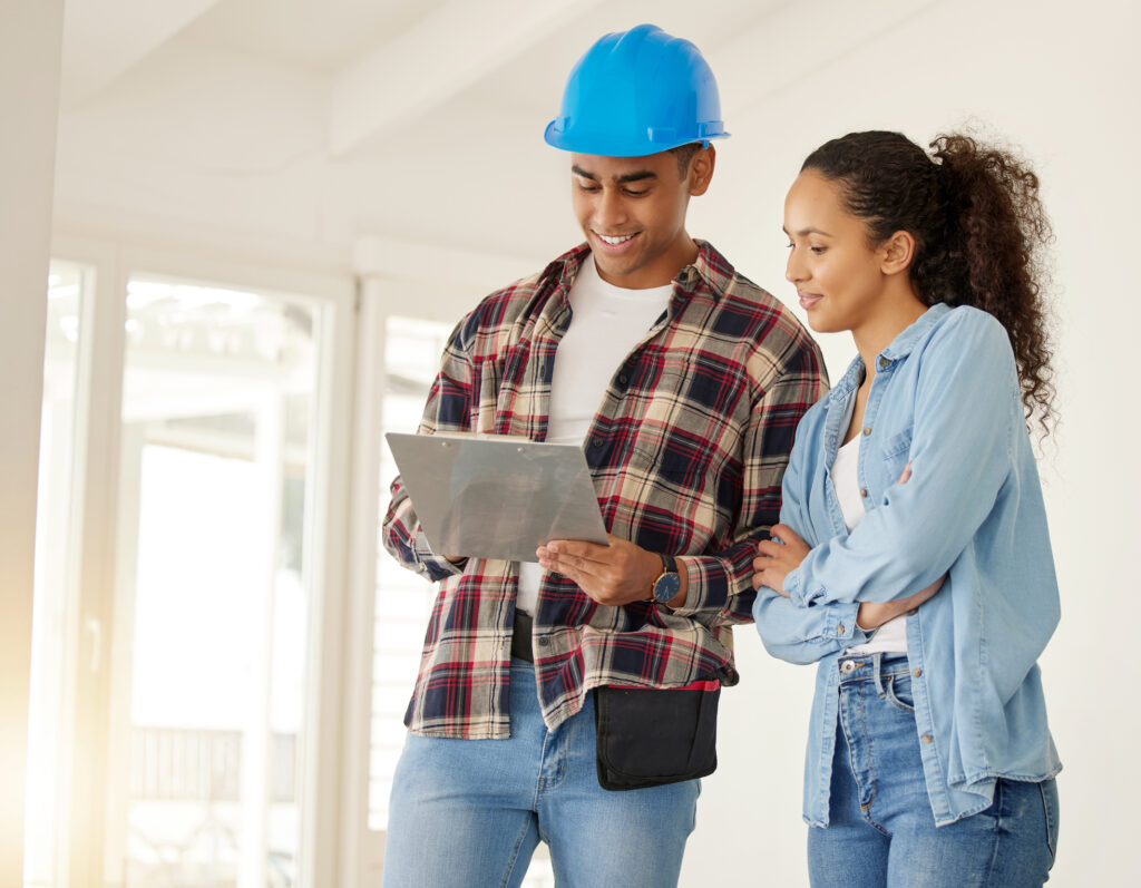 couple planning home renovation job together construction worker working with woman on maintenance and remodeling of apartment contractor and builder helping with interior design of family home