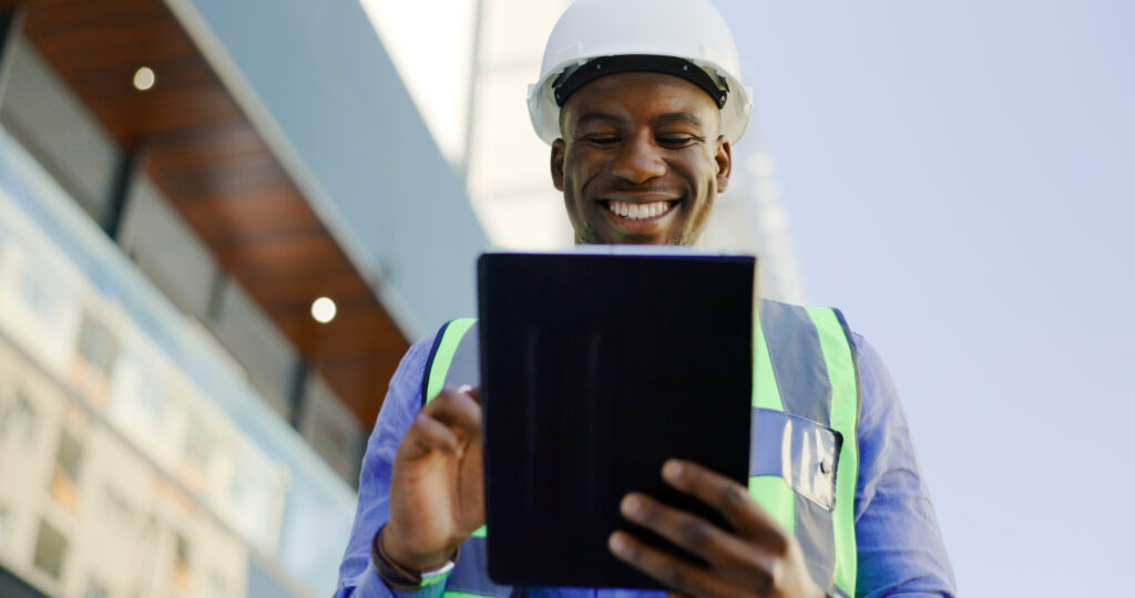 engineering man and tablet at construction site inspection building development and industrial renovation excited or happy african worker on digital tech design software or architecture planning