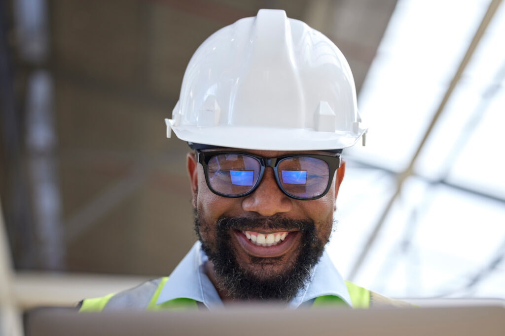 architecture planning and research with black man on construction site for engineering building and design technology idea and digital with face of contractor for project management and graphic