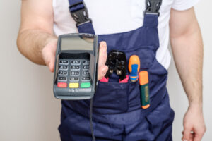 man with tools holding bank payment terminal salary concept